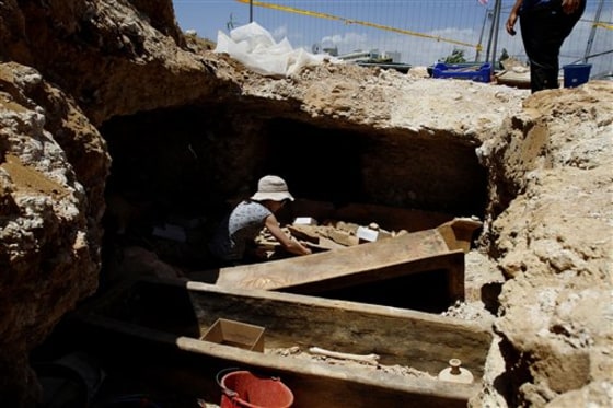 A Cyprus Antiquities Department archaeologist cleans a clay coffin estimated to be some 2,000 years old in the coastal resort of Protaras on Wednesday.